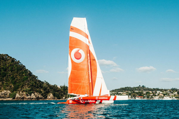 Racing yacht in open water sponsored by global brand.