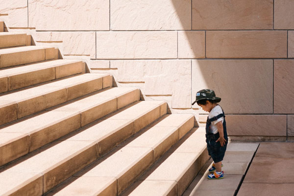 Small child with a big staircase to climb.